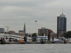 ein Fesselballon schwebt als Werbeträger über Hamburg; rechts das Hochhaus des „Hanseatic Trade Centers“